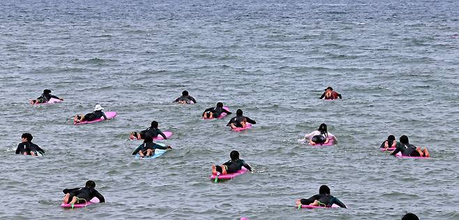 서핑 기초교육을 받은 수강생들이 파도를 타기 위해 바다로 나가고 있다. 이정용 선임기자 lee312@hani.co.kr