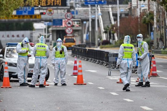지난 3월28일 코로나19 봉쇄령이 내려진 중국 상하이에서 보호복을 입은 경찰이 푸둥신구로 통하는 터널 통행을 막고 있다. [이미지출처=연합뉴스]
