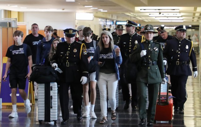 경찰관들이 로널드 레이건 공항에서 유가족들을 에스코트하고 있다.