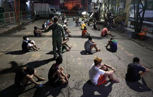 지난해 신종 코로나바이러스 감염증(코로나19) 확산을 막기 위해 한시적으로 시행된 야간 통행금지령을 어긴 필리핀 마닐라의 시민들이 경찰에 붙잡혀 대기 중이다. 필리핀스타 캡처