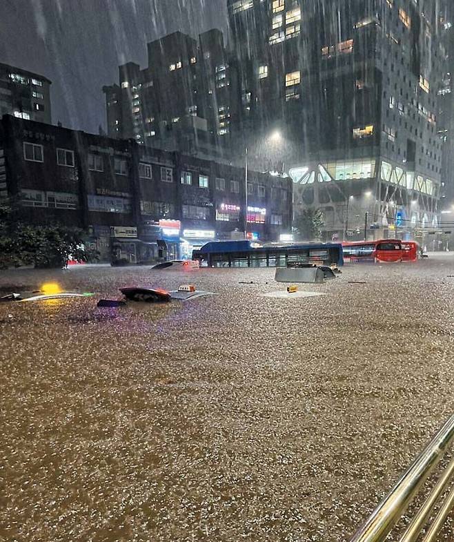물바다 된 강남… 택시 지붕까지 차올라 - 서울에 300㎜ 이상의 폭우가 쏟아진 8일 오후 10시 10분쯤 서울 서초구 진흥아파트 사거리 앞 도로에서 버스들이 빗물에 잠겨 있다. 이날 폭우로 서울 강남 도심 곳곳이 침수됐고, 서초구의 한 아파트에서는 정전이 발생한 데다 지하철 이수역 역사 일부가 무너지고 지하철 동작역이 폐쇄되는 등 피해가 끊이지 않았다. /트위터