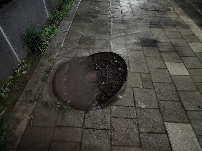 강남구 대치동의 한 도로 위 맨홀 뚜껑이 폭우로 수압을 견디지 못하고 열려있는 모습. / 독자 제공