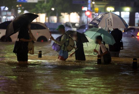 8일 밤 서울 강남구 대치역 인근 도로와 인도가 물에 잠기면서 차량과 보행자들이 통행하는 데 불편을 겪고 있다. 2022.8.8 연합뉴스