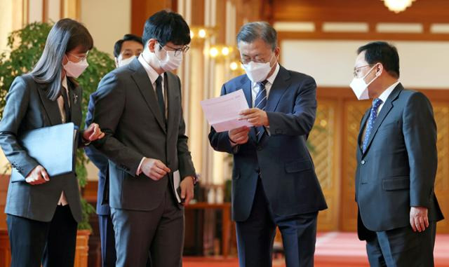 문재인(오른쪽에서 두 번째) 대통령이 5월 4일 청와대 본관에서 열린 백서 발간 기념 국정과제위원회 초청 오찬에 참석하며 탁현민(세 번째) 의전비서관에게 보고받고 있다. 왕태석 선임기자