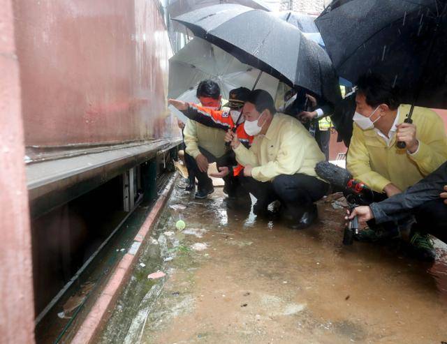 윤석열 대통령이 9일 간밤 폭우로 일가족 3명이 사망한 서울 관악구 신림동의 다세대 주택 현장을 둘러보고 있다. 오른쪽은 오세훈 서울시장. 뉴스1