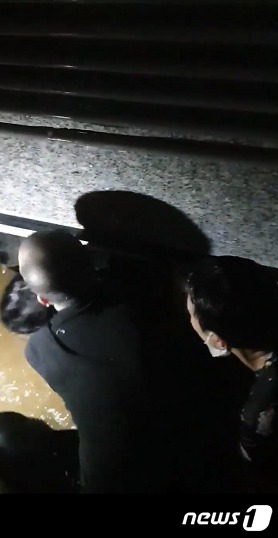 8일 밤 서울 신림동 반지하 주택에서 아이를 구하는 시민들의  모습.(독자 제공)ⓒ 뉴스1
