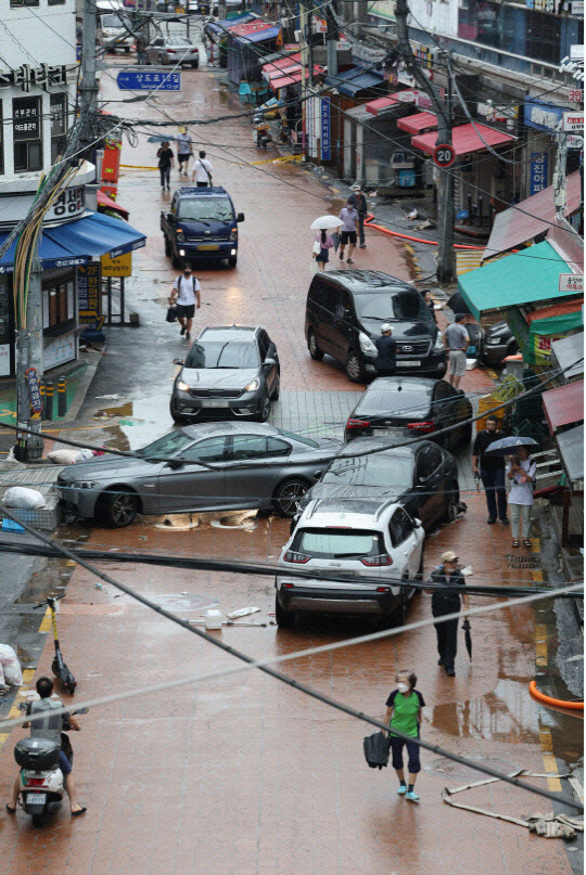 지난 9일 오전 서울 동작구 신대방 삼거리 인근 도로에 간밤의 폭우에 침수된 차들이 멈춰 서 있다. 연합뉴스