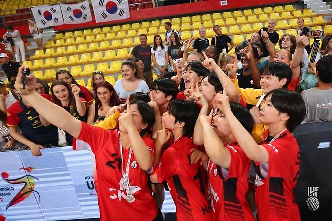 응원 온 다른 팀 선수들과 셀카 세리머니를 하는 한국 선수들. 세계핸드볼연맹 누리집 갈무리