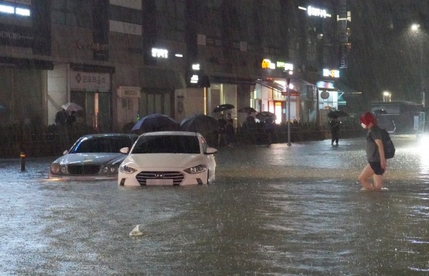 지난 8일 밤 서울 강남구 대치동 은마아파트 부근 도로와 인도가 물에 잠기면서 차량과 보행자가 통행하는 데 불편을 겪고 있다. 사진=연합뉴스