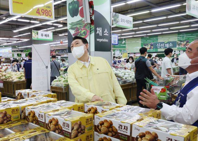 윤석열 대통령이 11일 서울 서초구 양재동 하나로마트 양재점에서 감자 가격표를 살펴보고 있다. 오른쪽은 신영호 농협유통 대표이사. 연합뉴스