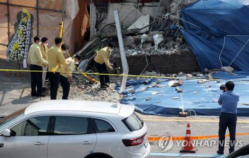 지난해 6월11일 오후 광주 동구 학동 재개발지역 건물붕괴 사고 현장에서 동구의회의원들이 헌화하는 모습을 수행원이 촬영하는 모습.(사진=연합뉴스)