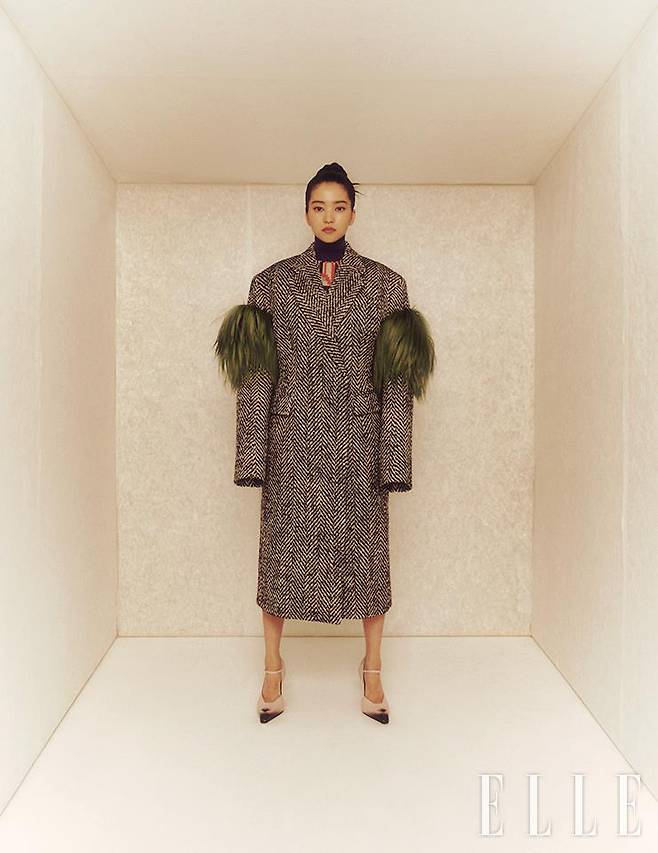 초록색 염소 털을 장식한 헤링본 코트와 기하학적 패턴의 니트, 토 부분에 그러데이션으로 포인트를 준 펌프스는 모두 Prada.