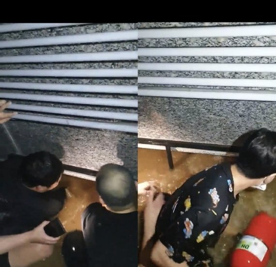 8일 밤 서울 신림동의 한 반지하 주택에서 폭우 속에서 아이를 구하는 남성들의 모습.(독자 제공)  뉴스1