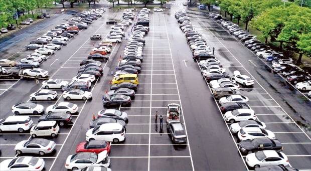 침수차로 ‘빼곡’ 집중호우에 침수 피해를 본 차량이 늘어나고 있다. 11일 경기 과천 서울대공원 주차장에 마련된 삼성화재, KB손해보험 임시 보상서비스센터에 피해 차량들이 주차돼 있다.    연합뉴스