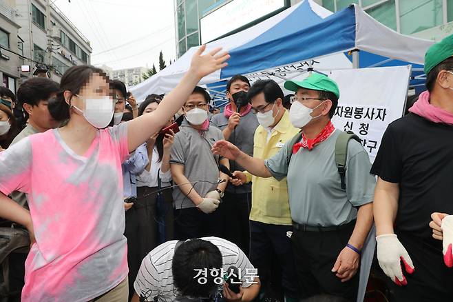 A citizen complains to the People Power Party leadership and yells, “What are you doing right now, blocking the road?” while Joo Ho-young, chair of the party’s emergency response committee, speaks on the microphone at the entrance of the Sadang 2-dong Community Service Center in Dongjak-gu, Seoul, before the party’s leadership volunteers for flood recovery activities on the morning of August 11. National Assembly press photographers