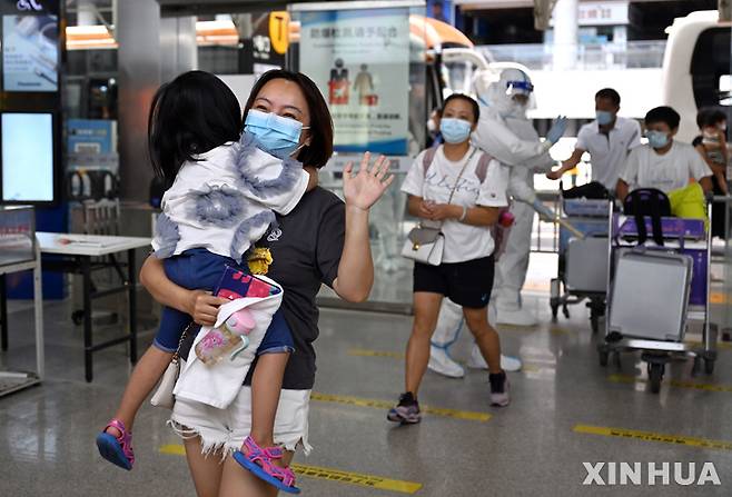 [싼야(하이난성)=신화/뉴시스] 지난 9일 하이난성 싼야 공항에서 한 관광객이 항공기 탑승을 앞두고 취재진에 손을 흔들고 있다. 2022.08.12