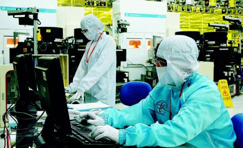 SK하이닉스 중국 우시 공장 직원들이 생산 라인에서 컴퓨터로 반도체 제조 상황을 점검하고 있다./SK하이닉스