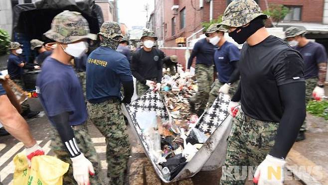 수해 복구 대민 지원에 나선 3공수여단 장병들이 13일 오후 대규모 수해를 입은 서울 관악구 신사동에서 비에 젖어 못 쓰게 된 물건들을 정리하고 있다.