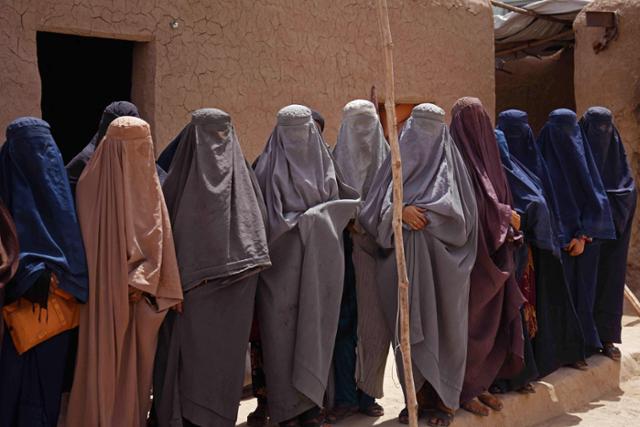 아프가니스탄 칸다하르의 한 공장에서 일하는 여성들이 부르카를 입고 있다. 칸다하르=AFP 연합뉴스