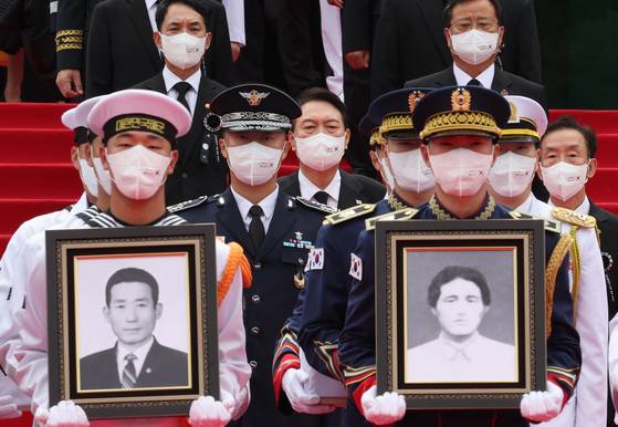 President Yoon Suk-yeol, center, takes part in a procession to transfer the remains of 17 independence fighters of the Korean Liberation Army to the Daejeon National Cemetery in a ceremony at the Seoul National Cemetery in Dongjak District, southern Seoul, Sunday. [YONHAP]