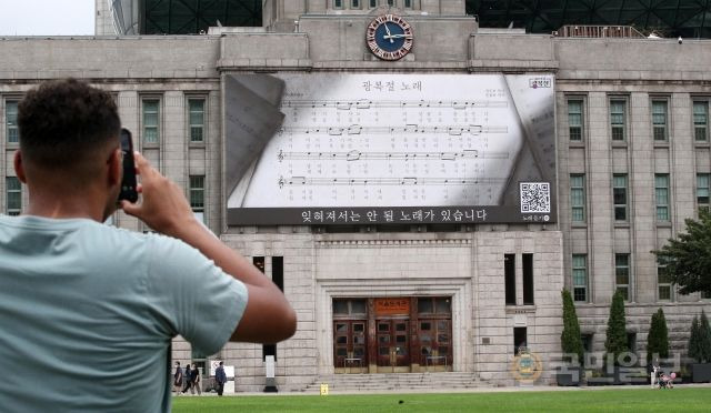 광복절을 하루 앞둔 14일 서울 중구 서울도서관 '꿈새김판'에 광복절 노래 악보가 걸려 있다. 광복 77주년을 맞이해 걸린 이 현수막에는 광복절 노래를 직접 연결할 수 있는 QR코드가 적혀 있다.