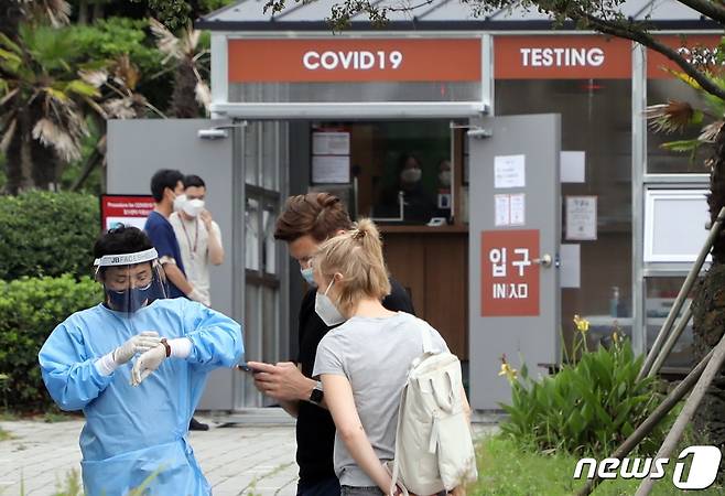 14일 오후 제주국제공항 주차장에 설치된 외국인 코로나19 검사센터에 서 한 외국인 관광객들이 안내를 받고 있다. 한국공항공사 제주본부는 제주공항 국제선 재개 및 최근 코로나 확산에 대비해 이날부터 공항 내에서 코로나 검사센터를 운영하고 있다.2022.7.14/뉴스1 ⓒ News1 고동명 기자