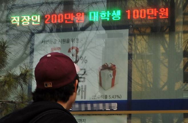 한 시민이 서울의 한 저축은행 앞 전광판에 적힌 '대출 광고'를 바라보고 있다. /조선DB
