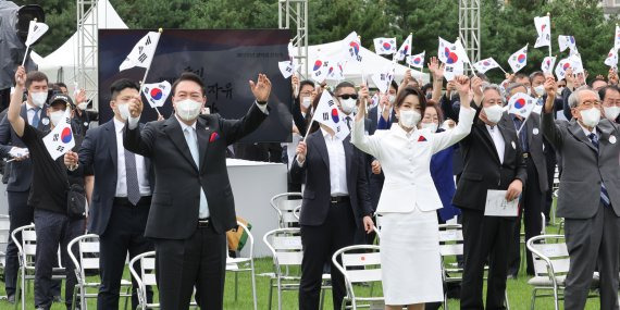 태극기 흔드는 대통령 내외. 윤석열 대통령과 김건희 여사가 15일 서울 용산 대통령실 청사 잔디마당에서 열린 제77주년 광복절 경축식에서 만세삼창을 하고 있다. 연합뉴스