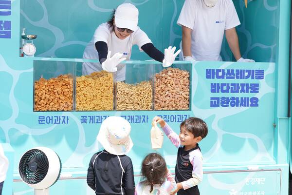 해안쓰레기를 과자로 바꿔주는 환경재단 ‘씨낵 캠페인’에 참여한 어린이들이 씨낵 트럭 앞에 서 있다. 환경재단 제공