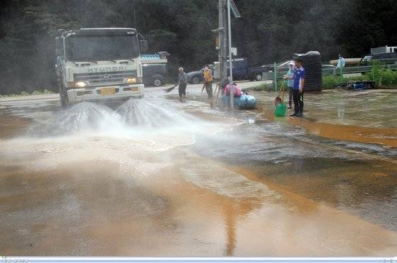 15일 충남 청양군 남양면 온직2리 마을회관 앞에서 살수차가 폭우로 인근 온직천이 범람하면서 쌓인 흙을 씻어내고 있다. 연합뉴스