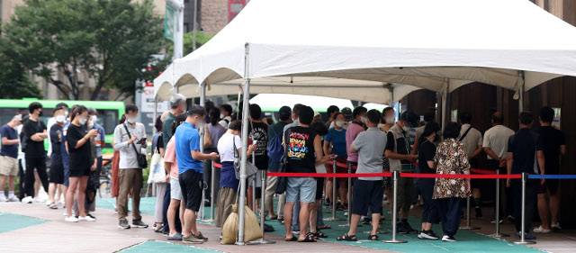 광복절 연휴에도 코로나19 확산세가 이어진 14일 오전 서울 송파구보건소 선별진료소에서 시민들이 코로나19 검사를 받기 위해 길게 줄지어 서 있다. 뉴시스