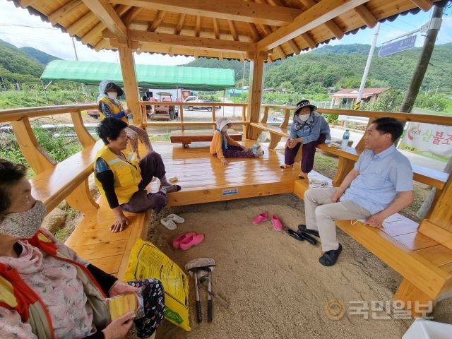 배용한 목사가 지난 5일 동네에 마련된 정자에서 작업 뒤 쉼을 갖고 있는 동네 어르신들과 이야기를 나누고 있다.