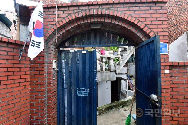 침수당한 반지하 방문을 열고 건조하고 있는 모습. 광복절이라 왼편에 태극기가 걸려 있다.