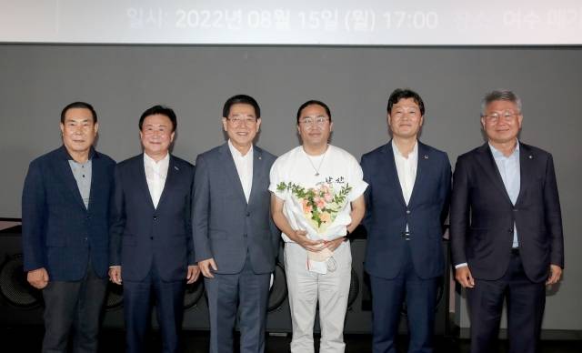 김영록(사진 왼쪽 세 번째) 전남도지사가 15일 오후 여수웅천 메가박스에서 열린 영화 ‘한산’ 무대인사 행사에서 김한민 감독에게 꽃다발을 전달하고 기념촬영을 하고 있다. 사진=전남도