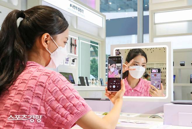 갤럭시 스튜디오 삼성 디지털프라자 홍대본점에서 방문객이 다양한 스티커로 직접 꾸민 ‘갤럭시 Z 플립4’로 거울셀피를 촬영하고 있다.|삼성전자