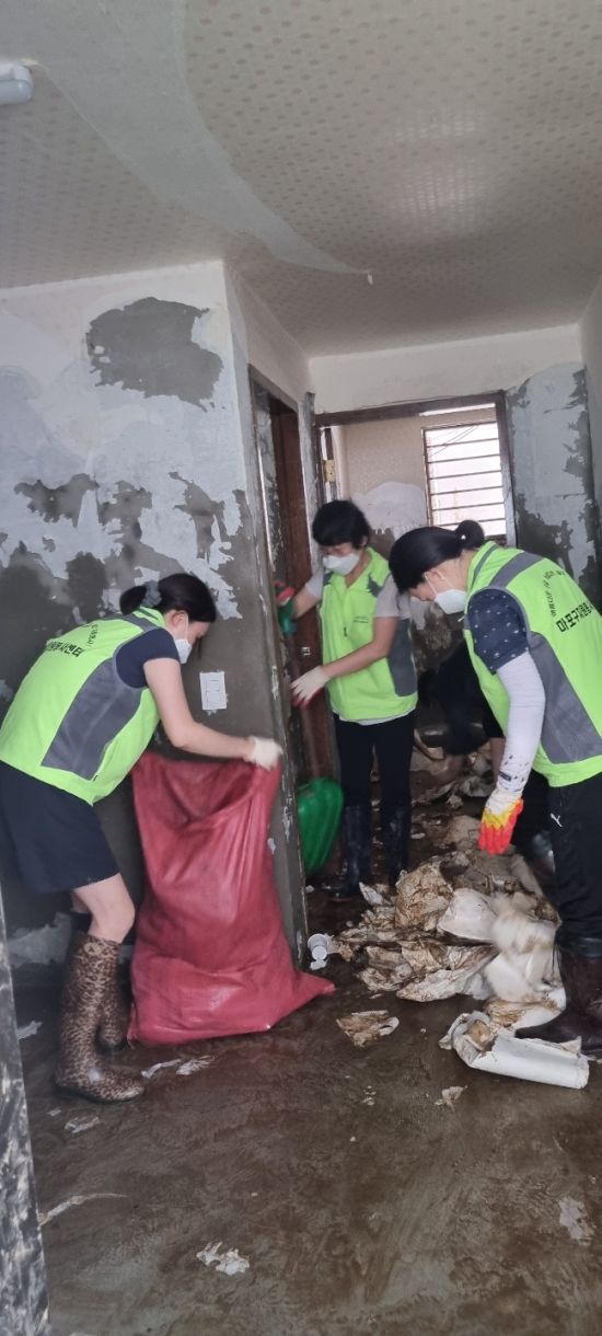 마포구 바로봉사단원들이 침수 현장에 쌓인 쓰레기 등을 치우고 있다.