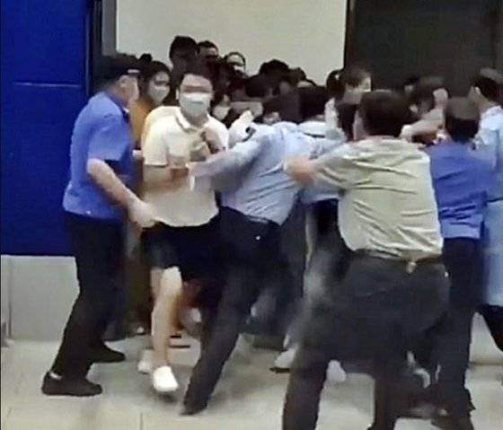 지난 13일(현지 시간) 중국 상하이 쉬후이 구역에 있는 이케아 매장이 코로나19로 긴급 봉쇄되자 일부 쇼핑객들이 문틈을 비집고 빠져나가려 안간힘을 쓰고 있다. 사진 웨이보 캡처