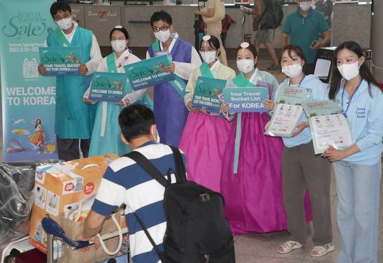 Officials from the Busan Tourism Organization and the Visit Korea Committee welcome Japanese tourists arriving at Gimhae International Airport on Tuesday as no-visa entry to Korea is allowed to Japanese tourists for about a month starting Aug. 4. [NEWS1]