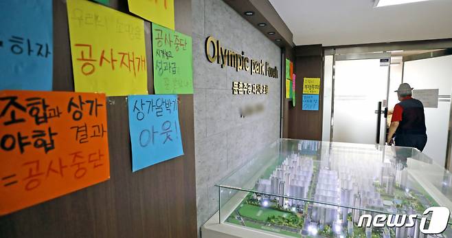 지난 12일 서울 강동구 둔촌주공 재건축 조합 사무실 앞으로 아파트 조합원이 지나가고 있다.  /사진=뉴스1