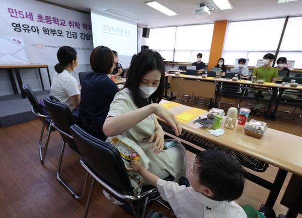 8월 5일 서울 용산구 사교육걱정없는세상 대회의실에서 열린 ‘만5세 초등학교 취학 학제개편안에 대한 영유아 학부모 긴급 간담회’에 한 학부모가 아이와 함께 참석하고 있다. / 연합뉴스