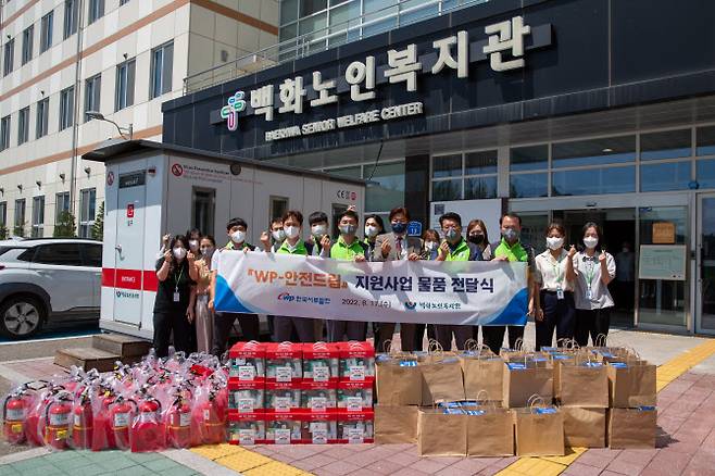 한국서부발전 관계자가 17일 본사가 있는 충남 태안군 백화노인복지관에서 지역 내 고령층·독거노인을 위한 450만원 상당의 소화기 및 재난용품 세트를 전달 후 기념촬영하고 있다. (사진=서부발전)