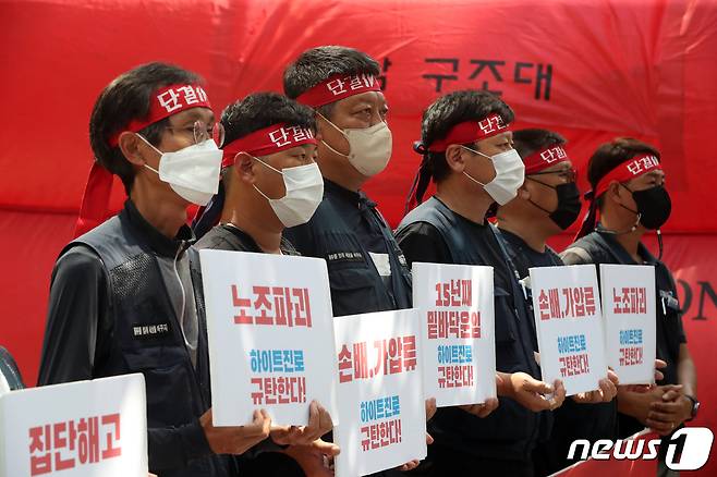 민주노총 공공운수노조 화물연대 조합원들이 16일 오후 서울 강남구 하이트진로 본사 앞에서 고공농성 돌입 기자회견을 진행하고 있다. 조합원들은 이날 조합원들의 복직과 손해배상 청구 철회 등을 요구하며 본사 옥상에서 점거 농성을 시작한다고 밝혔다. 2022.8.16/뉴스1 ⓒ News1 황기선 기자