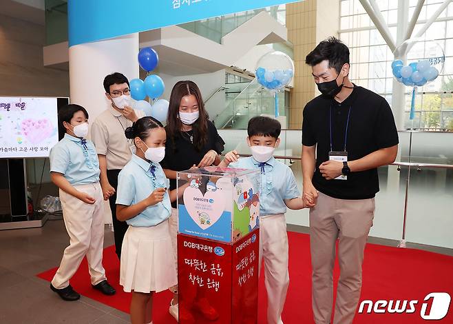 Change for Good 사랑의 외국 동전 모금 개시 행사에 참석한 대구 중구 구립 어린이 합창단원들이 DGB대구은행 본점 로비에 설치된 모금함에 동전을 기부하고 있다.(대구은행 제공)