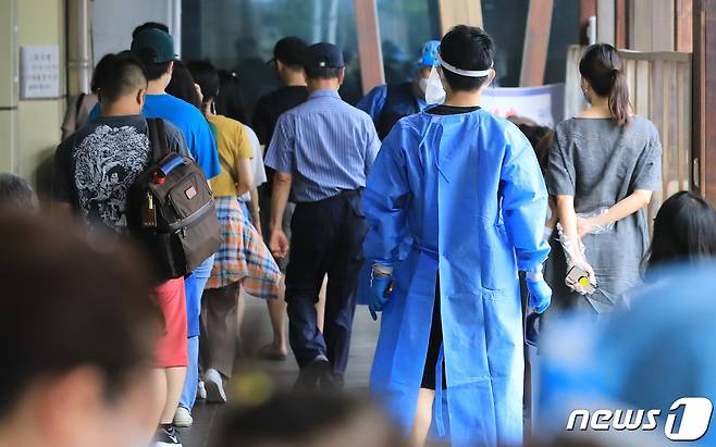 17일 오전 서울 송파구보건소에 마련된 신종 코로나바이러스 감염증(코로나19) 선별진료소에서 의료진이 검사를 위해 대기 중인 시민들을 안내하고 있다. 질병관리청 중앙방역대책본부는 이날 0시 기준 코로나19 신규 확진자가 18만803명 발생했다고 밝혔다. 2022.8.17/뉴스1 ⓒ News1 구윤성 기자