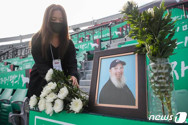 17일 부산 동래구 사직구장에서 고 캐리 마허 전 교수의 별세 소식을 들은 팬들이 캐리 마허가 자주 이용하던 좌석에 추모장소를 마련하고 있다. 2022.8.17/뉴스1 ⓒ News1 김영훈 기자