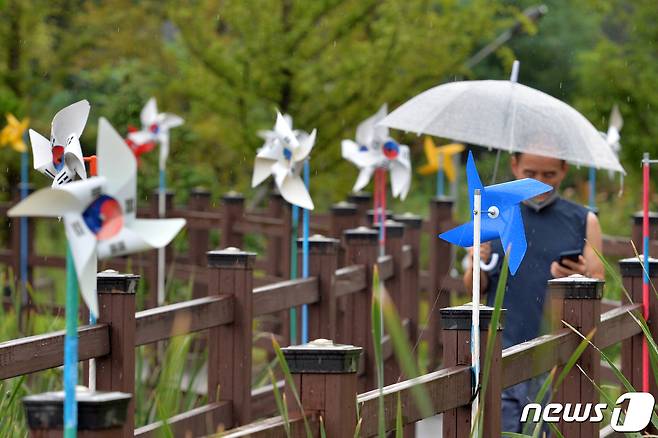 비가 내린 지난 16일 경북 포항시 북구 우창동 마장지에서 시민들이 태극기 바람개비길을 따라 산책하고 있다.2022.8.16/뉴스1 ⓒ 빅News1 최창호 기자