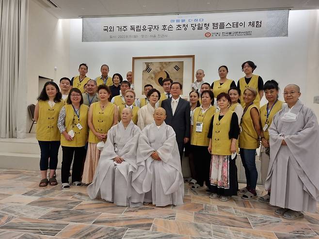 독립유공자 후손 초청 템플스테이 참가자들이 진관사 회주 계호 스님(앞줄 왼쪽 앉은 이), 주지 법해 스님(앞줄 오른쪽 앉은 이)과 함께 '진관사 태극기'를 배경으로 기념촬영했다. /김한수 기자