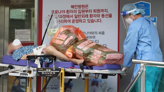 17일 오후 서울 광진구 코로나19 거점전담병원인 혜민병원에서 의료진이 환자를 이송하고 있다. 뉴시스