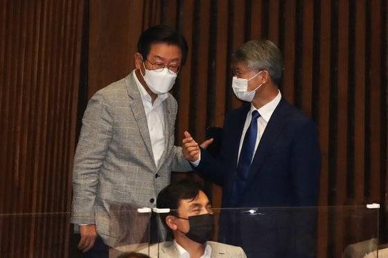 지난달 이재명 민주당 의원(왼쪽)과 민형배 무소속 의원(오른쪽)이 국회 본회의장에서 열린 대정부질문에 참석해 대화하고 있다. 가운데는 안규백 민주당 의원. 김상선 기자