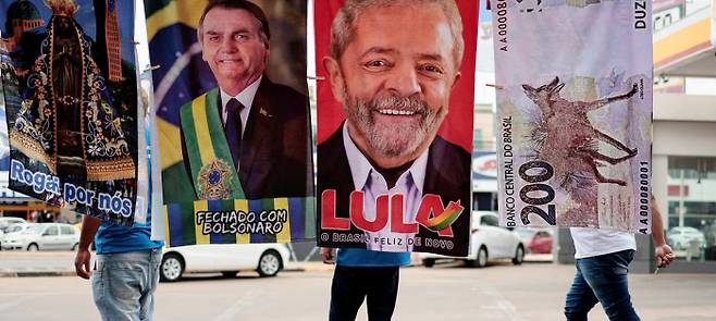 달아오르는 브라질 대선 열기 오는 10월 치러질 브라질 대선 공식 선거운동이 시작된 16일(현지시간) 루이스 이나시우 룰라 다시우바 전 대통령과 자이르 보우소나루 현 대통령의 지지자들이 플래카드를 들고 선거운동을 하고 있다. 브라질리아 | 로이터연합뉴스